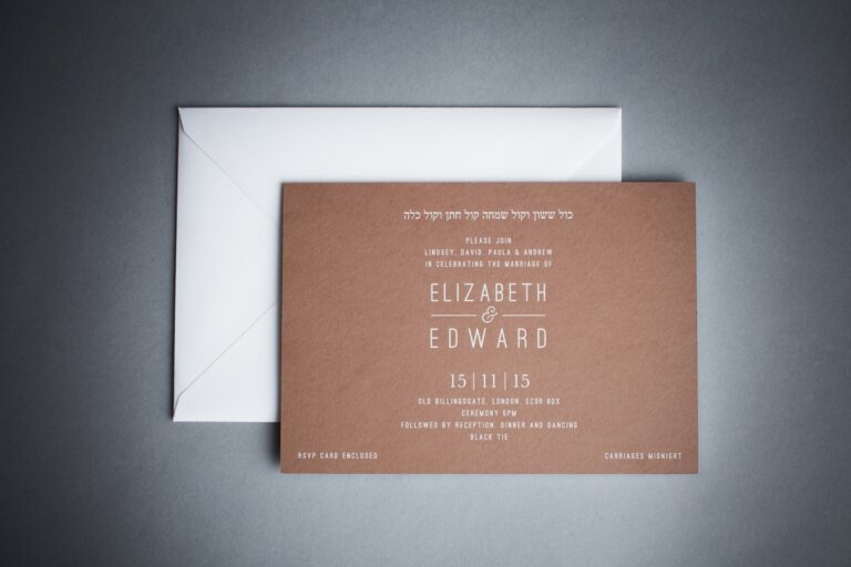 Minimalist engraved invitation in white on brown textured stock with a folded silver envelope, Downey Luxury Stationery