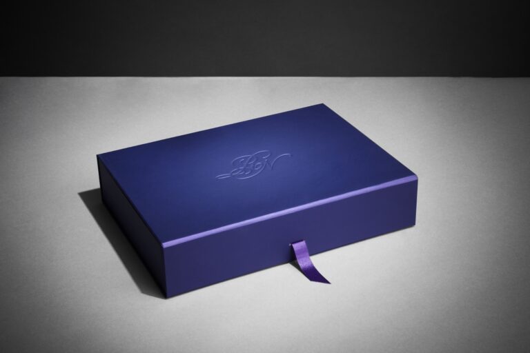 Soft-touch purple presentation box embossed with the couple's initials, for a multi-day Indian wedding, Downey Luxury Stationery