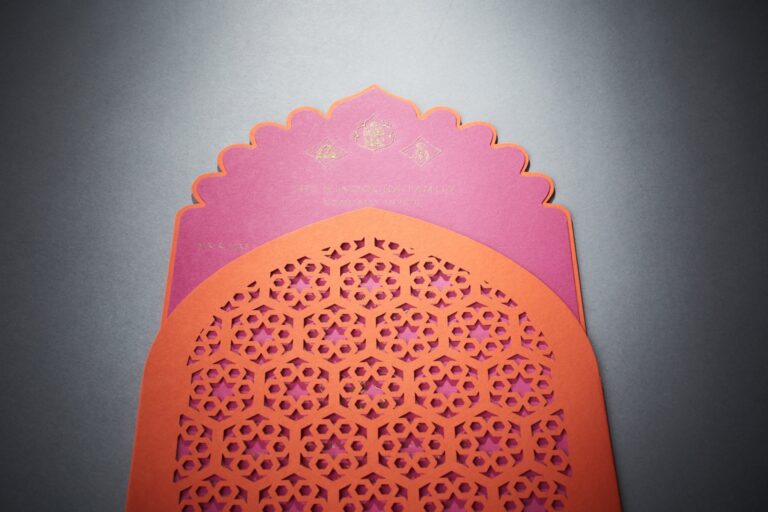 Invitation with a laser-cut door shape and geometric pattern in magenta and tangerine, Downey Luxury Stationery