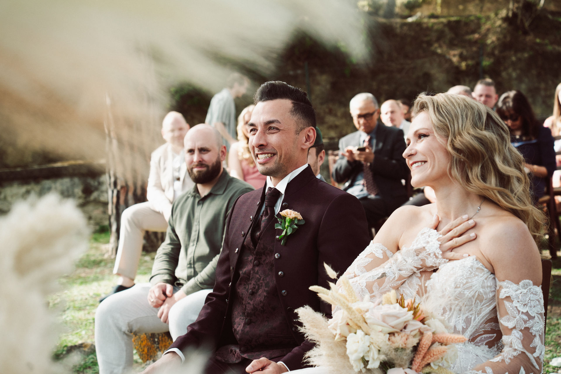 Bride and groom laughing together during the ceremony, guests seated behind, Dr Tiziana Di Molfetta