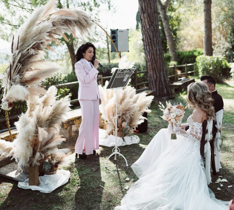 The celebrant at her lectern beside pampas grass floral arrangements, Dr Tiziana Di Molfetta