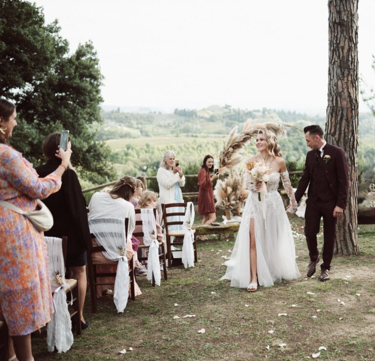 The couple walk down the aisle between rows of chairs, Dr Tiziana Di Molfetta