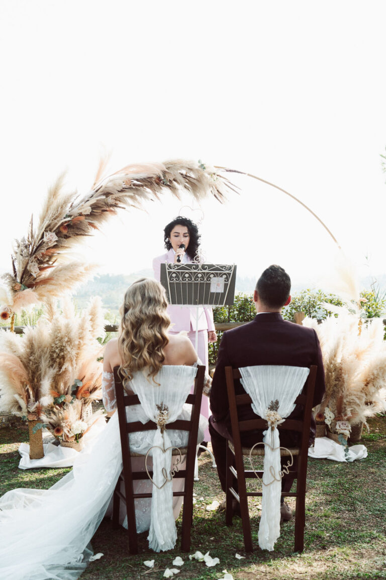 Ceremony set-up seen from behind the couple, with the celebrant at the arch, Dr Tiziana Di Molfetta