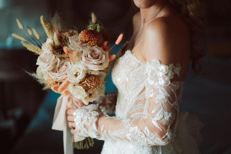 Bouquet of peach roses and dried grasses against the wedding dress, Dr Tiziana Di Molfetta