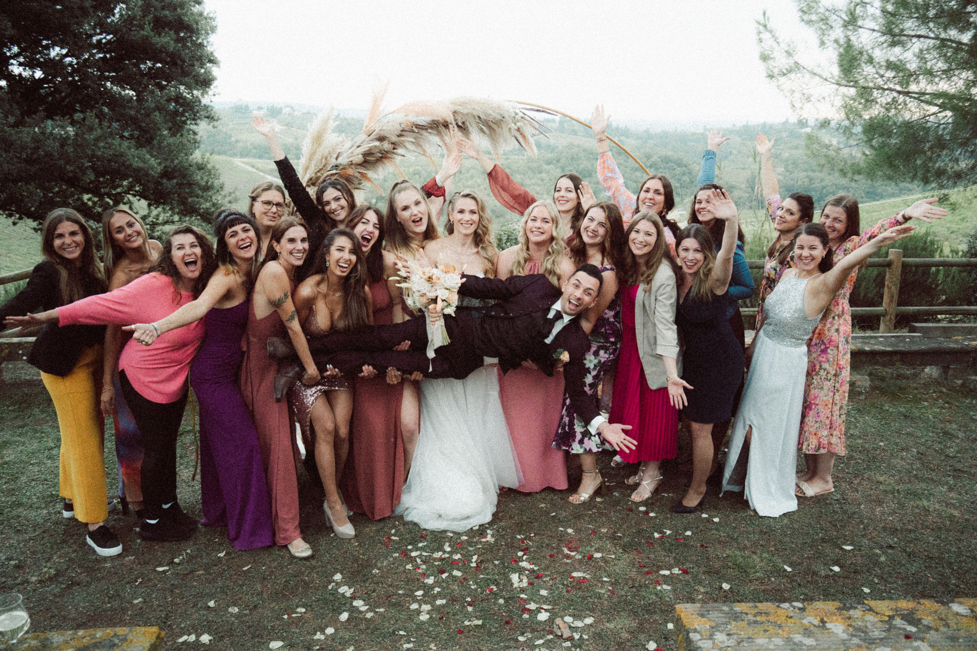 Wedding guests gather round the couple beneath the ceremony arch in the Florentine hills, Dr Tiziana Di Molfetta