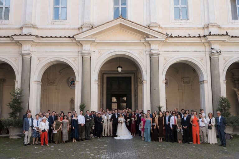 All the guests together in the arcaded courtyard of a neoclassical villa, Dream On Wedding Team