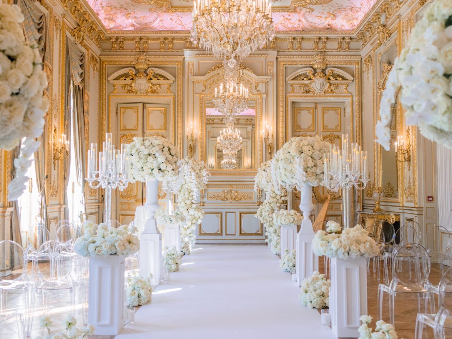 A ceremony aisle with white flower columns in a gilded Shangri-La Paris salon