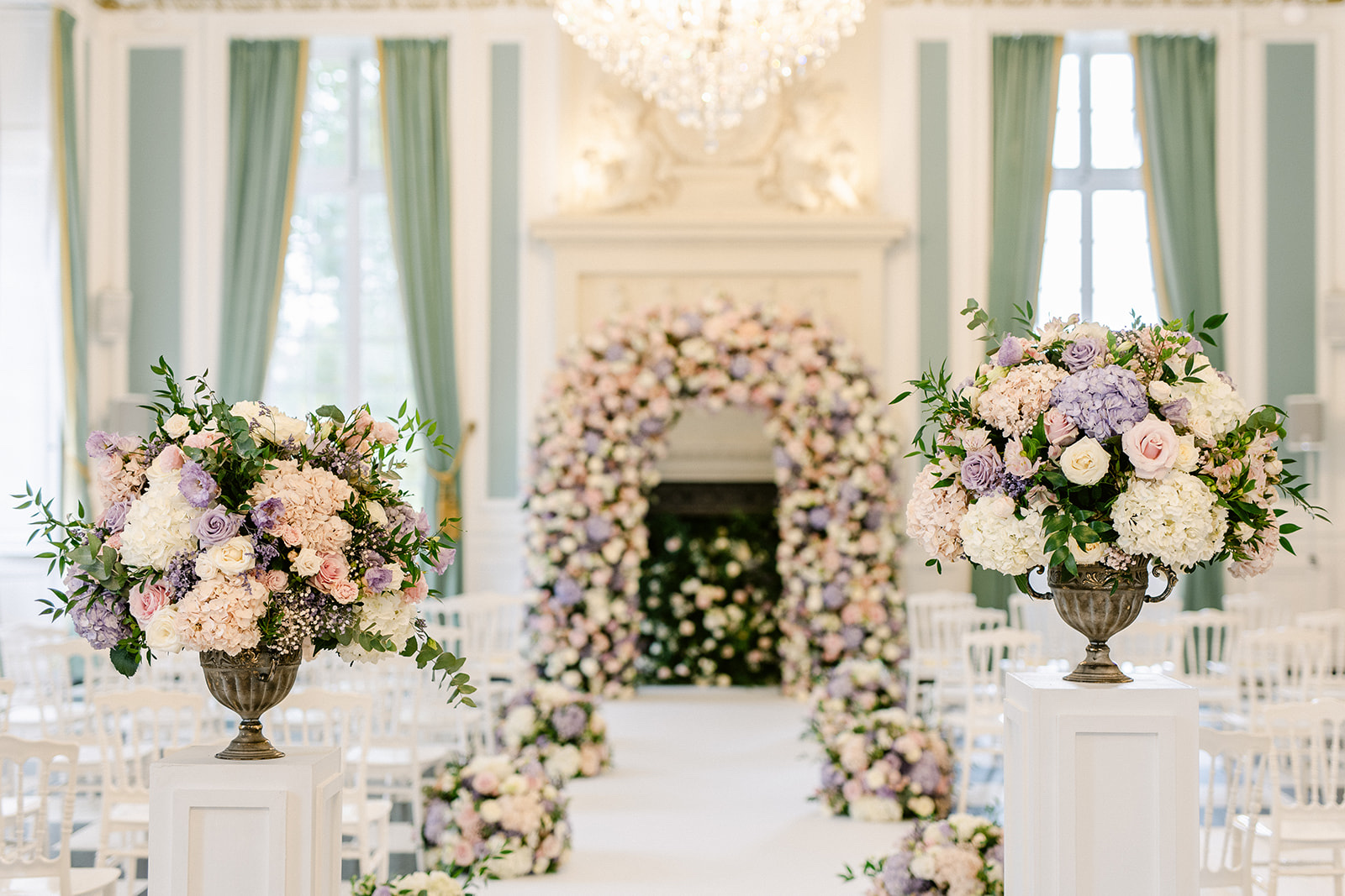 Flower arch at the end of a pastel salon aisle with urns of hydrangeas, Chateau Saint Martin du Tertre, Dream Paris Wedding