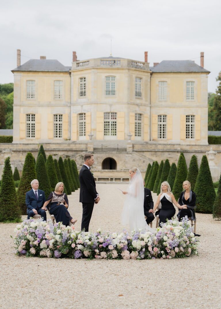 Ceremony set in a ring of lilac and white flowers on the chateau gravel, Dream Paris Wedding