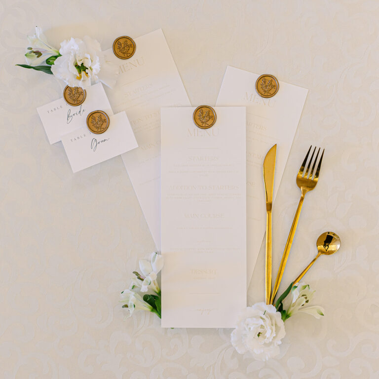 Menu cards with gold wax seals and cutlery on cream linen, Dream Paris Wedding