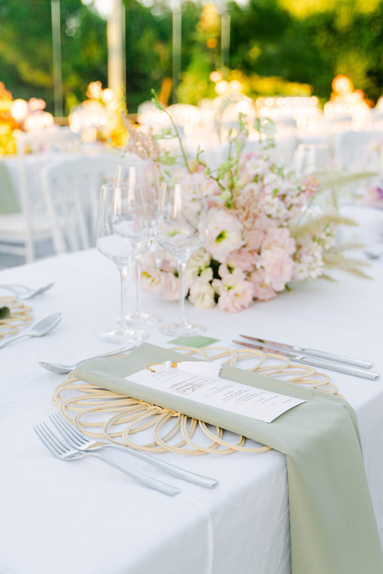 Place setting with sage napkin, gold charger and pale flower centrepiece, Dream Paris Wedding
