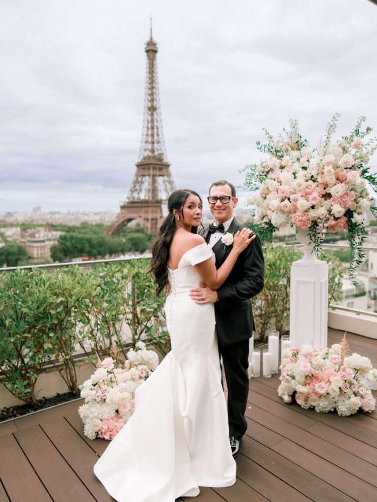 Rooftop terrace with white and blush flowers and the Eiffel Tower behind, Dream Paris Wedding