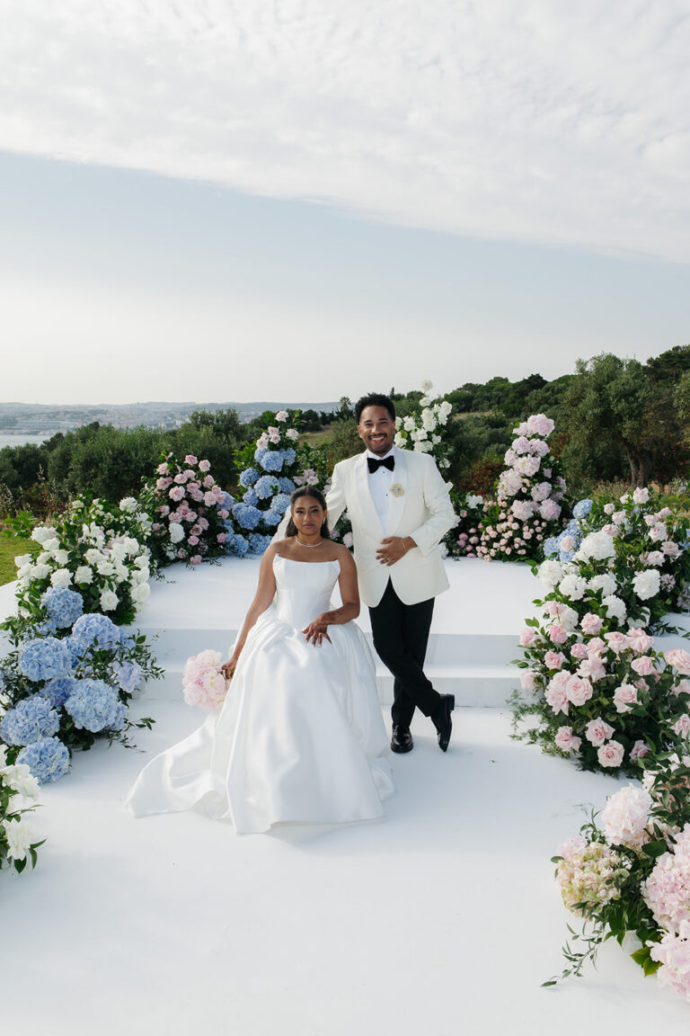 Couple on a white aisle ringed with blue and pink flowers, Dream Weddings Europe