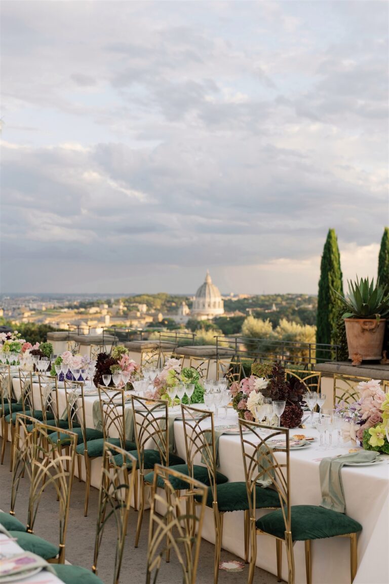 Long reception table with green chairs above Rome at dusk, Dream Weddings Europe