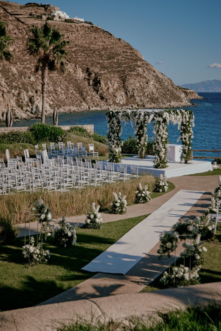 Ceremony seating laid out on a lawn above the sea, with a white aisle, Dream Weddings Mykonos
