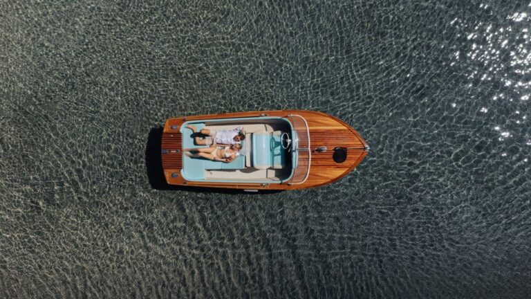 A wooden speedboat on dark water seen from above, Dream Weddings Mykonos