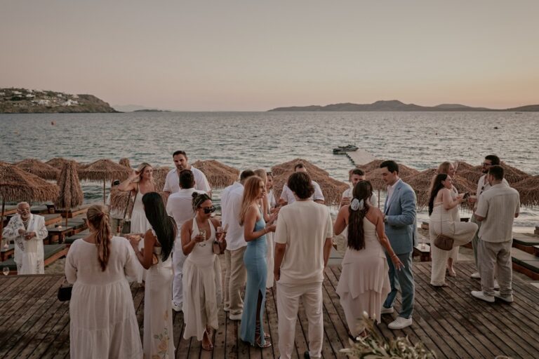 Guests in white gathered on a seafront deck at sunset, Dream Weddings Mykonos