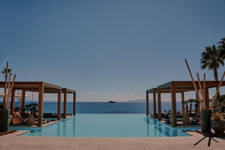 Pool with timber pergolas and loungers looking out to the sea, Dream Weddings Mykonos