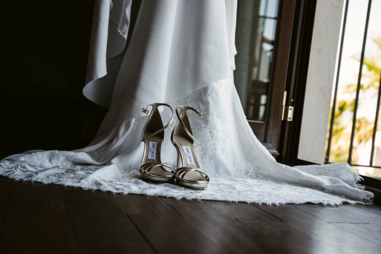 Bridal shoes resting on the train of the dress by an open window, DS Studiofotografico