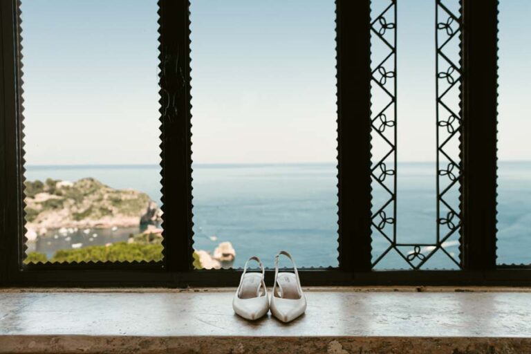 Bridal shoes on a window ledge looking out over the sea, DS Studiofotografico