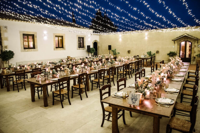 Long tables set under a canopy of fairy lights before the reception, DS Studiofotografico