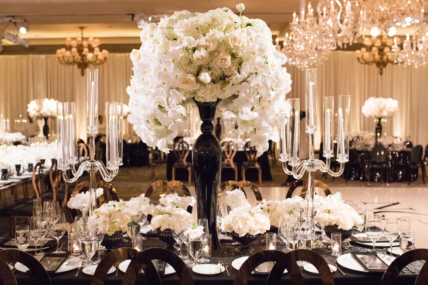Reception table with a tall white floral centrepiece and candelabra, Montage Laguna Beach, Duke Photography