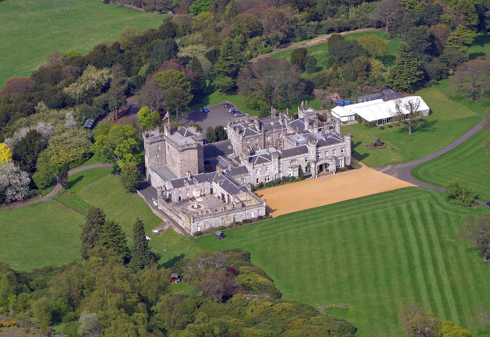 The castle, Pavilion and striped lawns seen from above, set in woodland and parkland, Dundas Castle