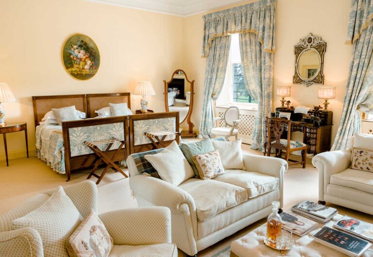 A twin bedroom with a sitting area and a window onto the grounds, Dundas Castle