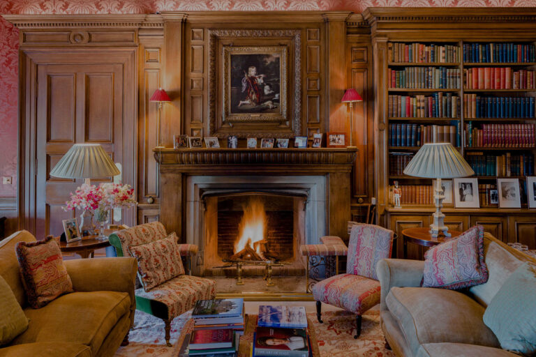The silk-walled Library with its fireplace, bookcases and armchairs, Dundas Castle