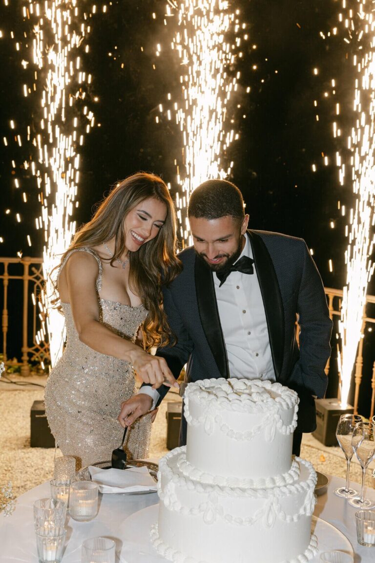 Cutting a white tiered cake between sparkler fountains at night, Lake Como, Elisa Prati Wedding Italy