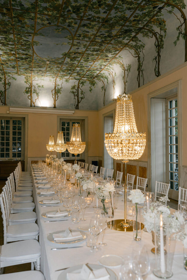 A long table under crystal chandeliers in a frescoed villa room, Lake Como, Elisa Prati Wedding Italy