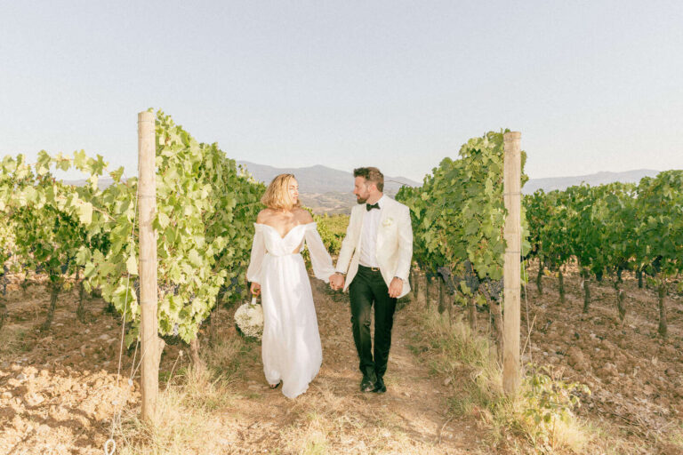 The couple walking between vine rows in Tuscany, Elisa Prati Wedding Italy