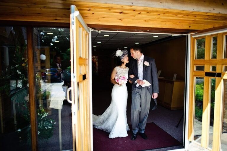 A bride and groom stepping out through the doorway, Le Manoir aux Quat'Saisons, Elizabeth Hsieh Make Up Artist