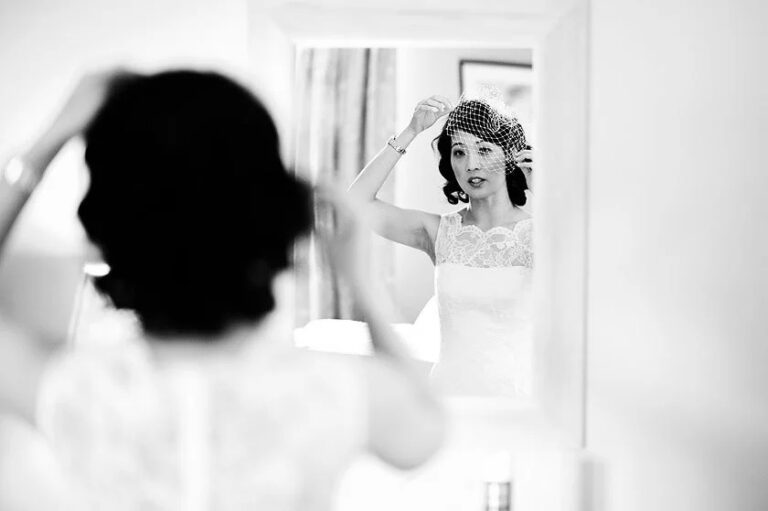 A bride adjusting her birdcage veil in the mirror, Le Manoir aux Quat'Saisons, Elizabeth Hsieh Make Up Artist