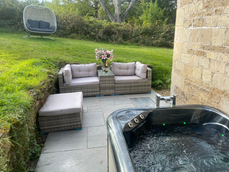 The private garden at Church Lodge, with outdoor seating and a hot tub, Elmhay Park