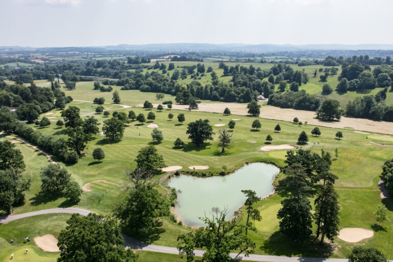 The estate's 18-hole golf course and a lake from the air, with the Somerset countryside behind, Elmhay Park