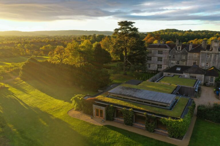 The Gillyflower, its living roof set into the gardens, the main house beyond, from the air, Elmore Court