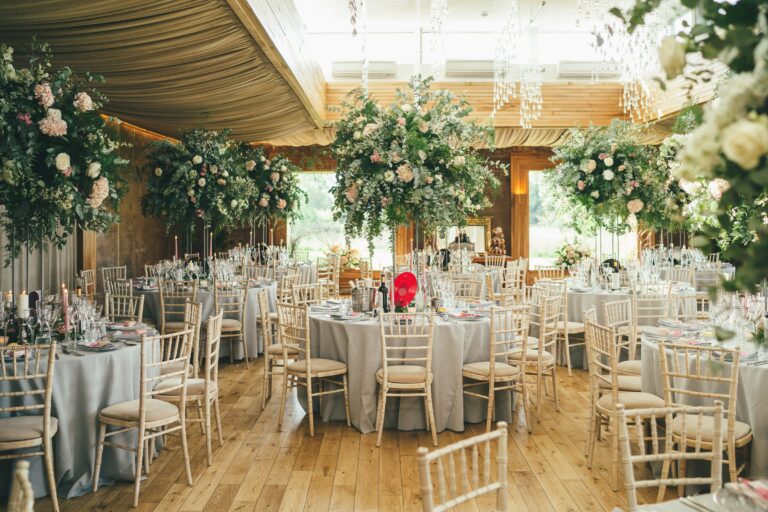 The Gillyflower set for a wedding dinner, floral installations beneath the timber roof, Elmore Court