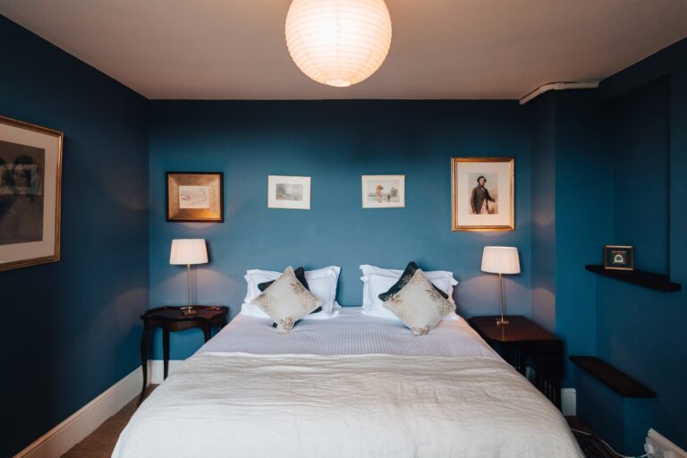 A blue-painted bedroom with a double bed and a pendant light, Elmore Court