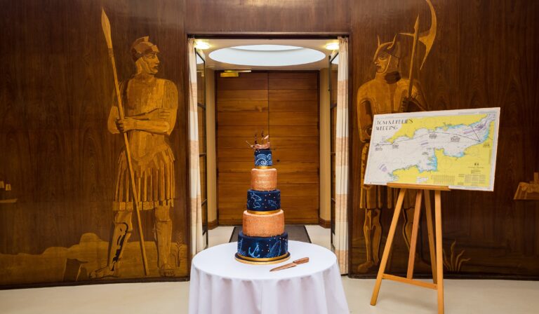 A celestial Art Deco wedding cake before the marquetry figures of the Entrance Hall, Eltham Palace