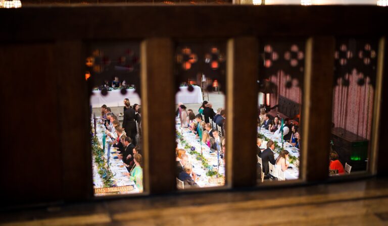 A wedding dinner glimpsed through the balustrade of the minstrels' gallery, Eltham Palace
