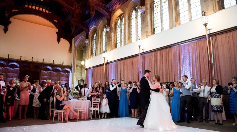 A first dance on a starlit floor in the Great Hall, guests gathered beneath the Gothic windows, Eltham Palace