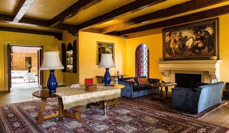 The Drawing Room, blue velvet sofas and a large painting beneath a beamed and gilded ceiling, Eltham Palace