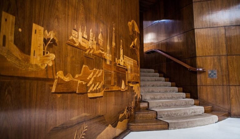 Marquetry cityscapes inlaid into the walnut wall beside the Entrance Hall staircase, Eltham Palace