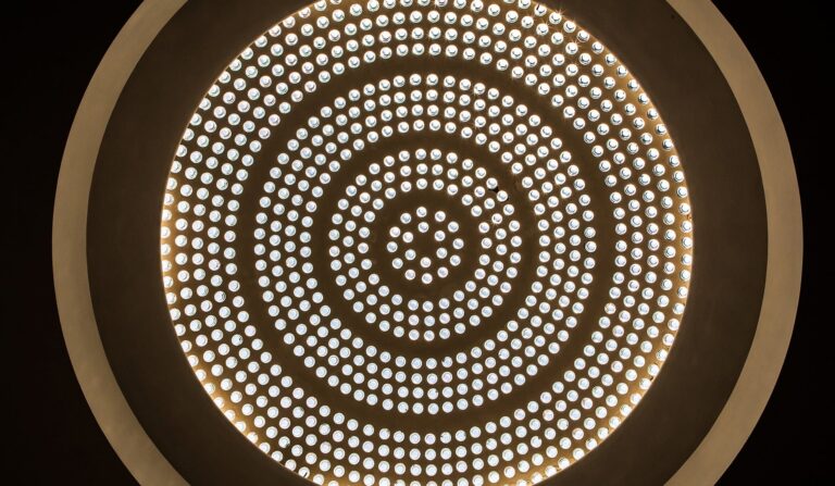 The shallow glass-and-concrete dome of the Entrance Hall, lit from within, Eltham Palace