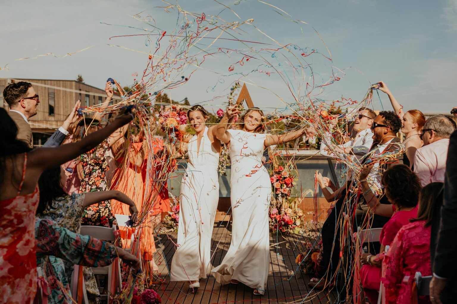 Guests cheering and throwing streamers around the couple after the ceremony