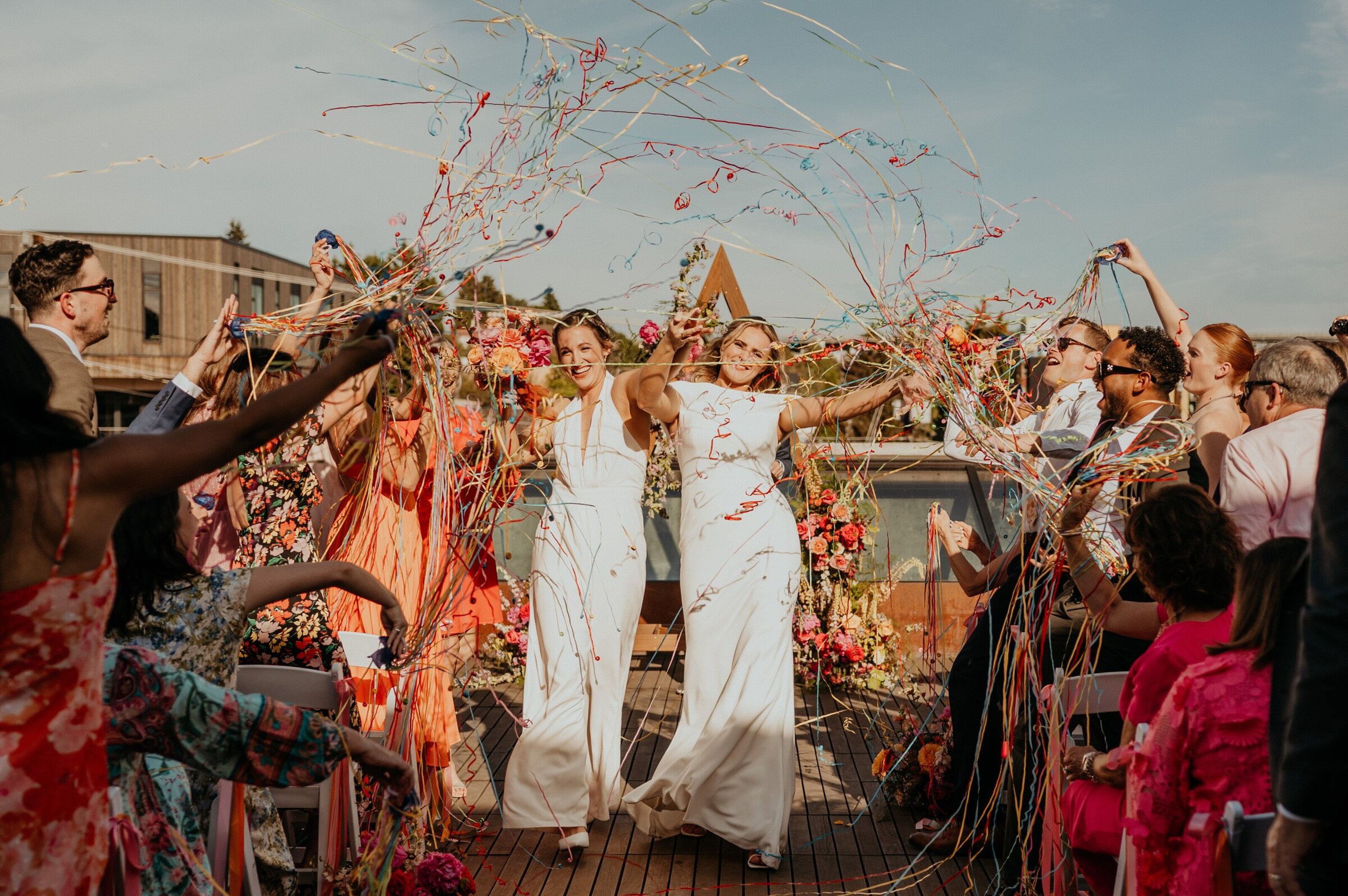 Guests cheer and throw streamers around the couple after the ceremony, Emett Joseph Photography