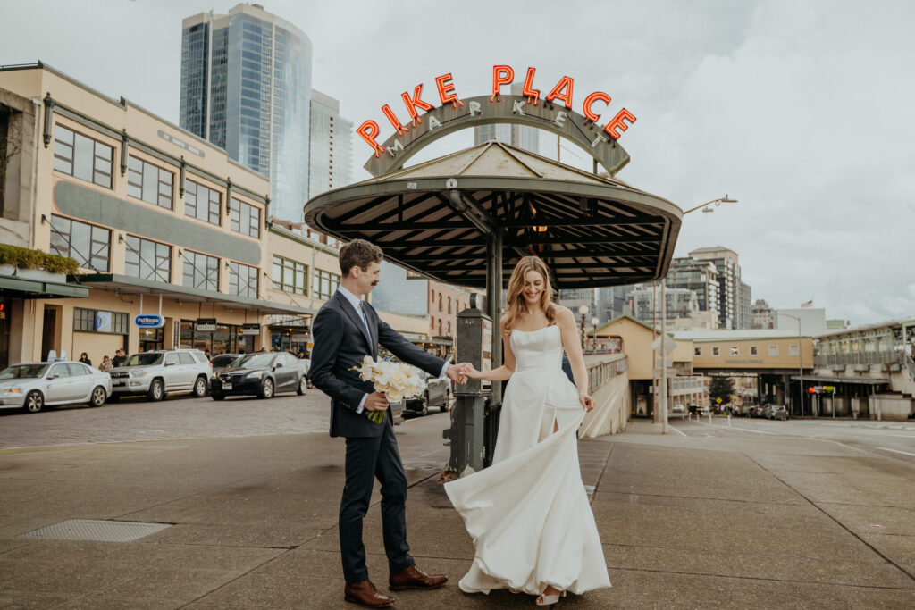 Couple in front of the Pike Place Market entrance sign in Seattle, Emett Joseph Photography
