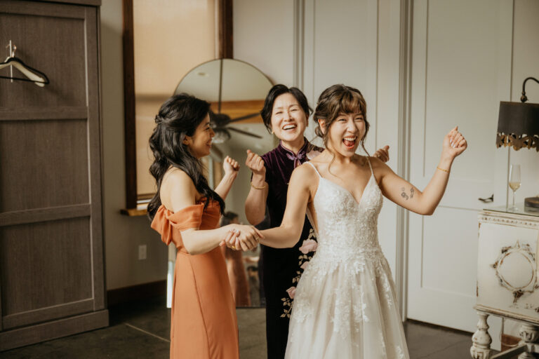 Bride laughing with her bridesmaids in a bright room while getting ready, Emett Joseph Photography