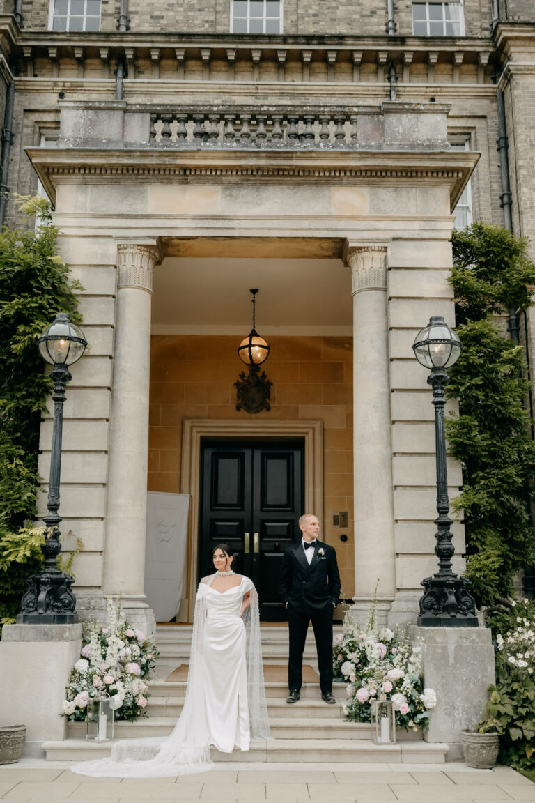 A couple on the front steps of Hedsor House, framed by the portico, Emma-Jane Photography